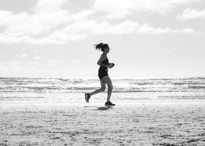 A woman jogging on La Lucila del Mar beach, Argentina in a monochrome setting. Capturing fitness and freedom.